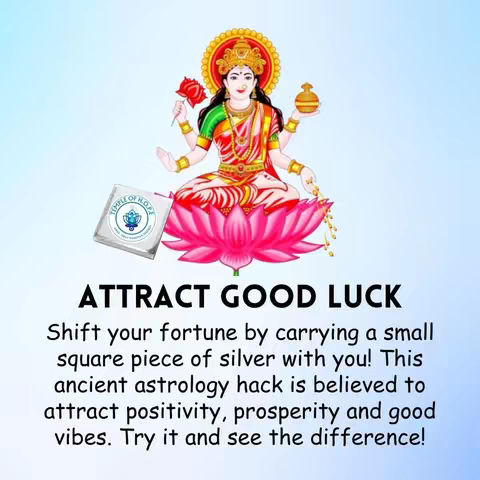 The image features a seated female figure with multiple arms, adorned in red and gold clothing, floating above a pink lotus flower. The figure is surrounded by a golden halo and holds items in her various hands. The text overlay reads "ATTRACT GOOD LUCK" in bold, black letters. Below, supporting text explains an astrology hack to attract positivity, prosperity, and good vibes.