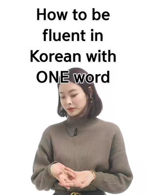 A woman in a brown mock-neck sweater poses against a white background. The text overlay states 'How to be fluent in Korean with ONE word'.