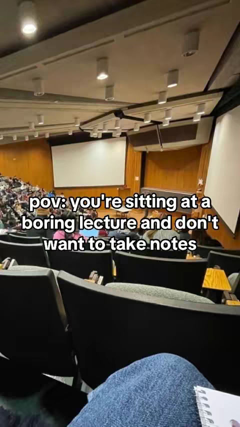 The cover image shows a POV from a person sitting in a lecture hall, looking towards a projector screen. The hall is filled with rows of seats, with a portion of the seated audience visible. White text overlays the scene, conveying a student's perspective.