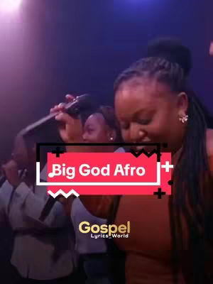 A shot from a live performance with a woman in the center holding a microphone, singing, with other women in the background. The image is a medium shot with a red and white overlay that reads "Big God Afro" and the lower right corner has a white corner with "Gospel lyrics_world" in a cursive, with a black background.