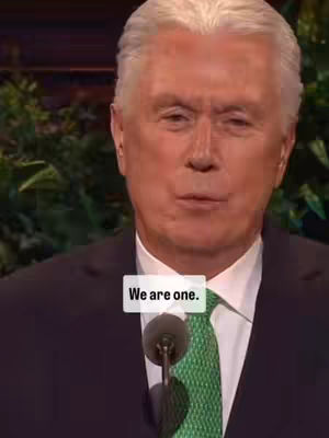 The cover image features a close-up of Elder Uchtdorf speaking at a podium, wearing a dark suit, a green tie with a pattern, and a white shirt. A text overlay containing the words "We are one." is displayed against a white background. The lighting appears professional, likely from a conference setting.