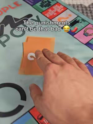 A hand is reaching for a card on a game board. The game board has colorful squares and the text overlay says "The punishments can't be that bad"