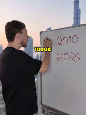 A man in a black t-shirt is standing in front of a whiteboard, writing with a red marker. The background is a cityscape at sunset.
