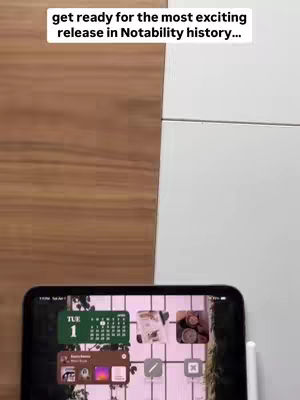 The cover image shows the top of a wooden surface on the left and a white surface on the right. In the bottom center, there is a black tablet with its screen visible. The screen displays a digital calendar widget, app icons arranged in a grid, and elements of a user interface. A white stylus is seen on the right side of the image.