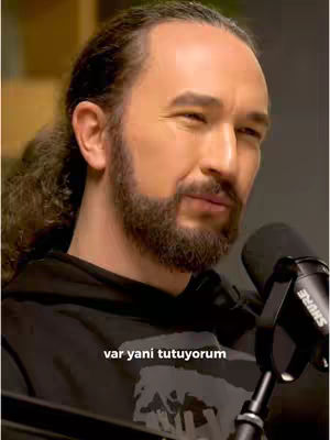 The cover image shows a man with long hair and a beard, wearing a dark hoodie. He's holding a microphone, suggesting a podcast or interview setting. The text overlay indicates the video discusses financial markets.