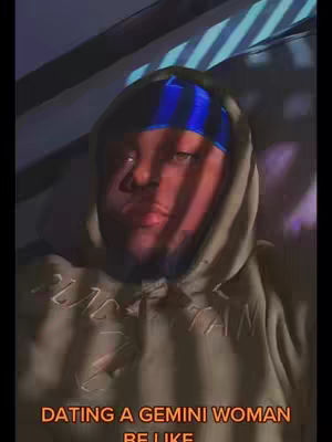 The image shows a man wearing a hoodie and a blue and black durag, lying down. The lighting casts shadows with stripes across his face. Text at the bottom reads 'DATING A GEMINI WOMAN BE LIKE'.