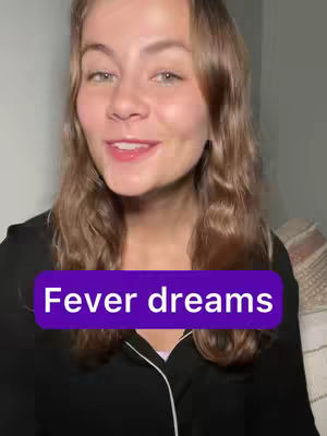 The cover image features a woman with long, wavy brown hair and fair skin, facing the camera in a medium shot. She is smiling with slightly parted lips, and wearing a black top with a white trim. A purple rectangle with white text that reads 'Fever dreams' is superimposed at the bottom of the frame. The background is softly lit, suggesting an indoor setting. Overall, the image has a warm, inviting feel.