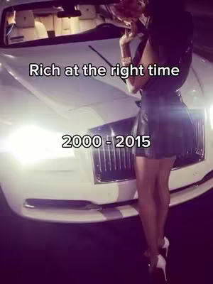 A woman in a black dress stands next to a white luxury car, with text overlays, emphasizing luxury and the 2000s era.