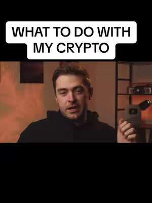 The cover image displays a man against a blurred background, with a text overlay at the top. The man, who appears to be the central figure, is wearing a black hoodie and looking at the camera. Above him, a text field with a white background and black border says 'WHAT TO DO WITH MY CRYPTO.' The background is a mix of warm, orange and brown tones, suggesting a well-lit interior or studio setup, with some equipment to the right side.