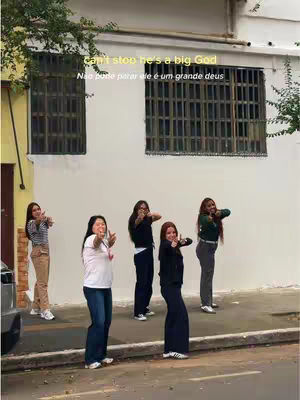 The image shows five women standing in front of a building with large windows. They are all smiling and flashing the peace sign with their hands, with the thumbs up. The women are diverse in terms of dress and skin tones. The caption has messages written overlayed on top of the image.