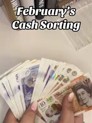 The cover image features a hand holding a fanned out arrangement of various British banknotes—predominantly purple £5, blue £10, and brown £20 notes. Above the bills is overlaid text in a bold, white font with a black outline. The background is a light-colored surface, likely a table, and includes the blurred outlines of containers and objects.