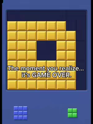 The cover image is a game interface featuring a puzzle board filled with gold-colored square blocks arranged in a grid. A portion of the blocks is missing, leaving a space shaped like a square combined with an L. Below the main game board, there are two smaller areas displaying different colored blocks: blue squares on the left and green squares on the right. The color palette is dominated by gold, blue, and green against a dark blue background. Overlaying the game board is text in white font.