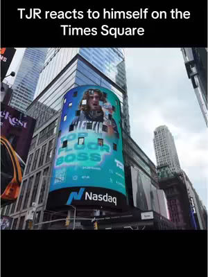 The cover image shows a man featured on a digital billboard in Times Square, New York City. The billboard displays the man's image, surrounded by a turquoise and blue design, and the text "TOP FLOOR BOSS." The Nasdaq logo is visible. He appears to be reacting to the display. Additional billboards and high-rise buildings surround the main elements. The sky is overcast, and the overall scene is bright.