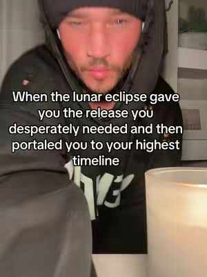 A man in a black hoodie with text overlay, in a close-up shot with blurred background elements.