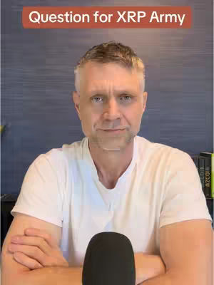 A man with short, graying hair is centered in the frame, wearing a white t-shirt. The background features a navy blue wall. Above the man is an orange rectangular box with white text, 'Question for XRP Army'. The man's arms are crossed, and a black microphone obscures the lower center.