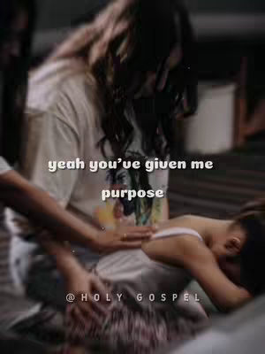 The image depicts a scene with two figures, an adult and a child, in a dimly lit setting. The adult, with long, dark hair, is partially out of focus but appears to be holding the child, whose face is obscured. The child is wearing white clothing, while the adult's attire is light-colored. The background has a blurred effect with warm tones. Overlayed text in a white font reads 'yeah you've given me purpose', further emphasizing the theme within the video.