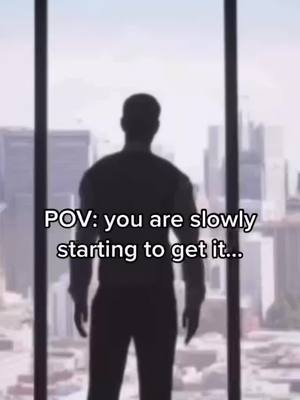 A silhouette of a person standing in front of a large window, looking out on a cityscape. The person is dark against the bright background.