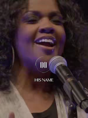 The cover image features a woman with dark hair, singing into a microphone. A stylized graphic, labeled "HIS NAME", is layered near her face. The lighting is soft and the background is dark.