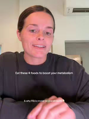 A woman is in the close-up, wearing black shirt. The background is white with a air conditioner. Bottom of the image there is hands.