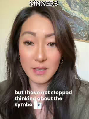 A woman with dark hair is centered in the frame, looking towards the camera with a neutral expression. Text overlays at the top and bottom of the image. The upper text reads "SINNERS" in a stylized font. Below the woman, white text reads: "but I have not stopped thinking about the symbo". In the background, a framed painting of a starry night.
