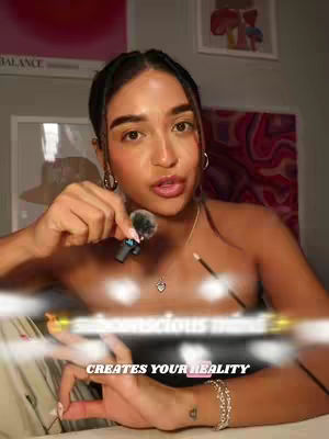 A woman is holding a microphone and a pencil. The text overlays read "SUBCONSCIOUS MIND" and "CREATES YOUR REALITY."