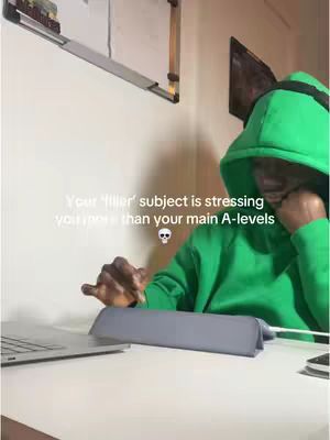 The cover image shows a person wearing a green hoodie sitting at a desk with a laptop and tablet. The text overlay reads: Your ‘filler’ subject is stressing you more than your main A-levels, followed by a skull emoji