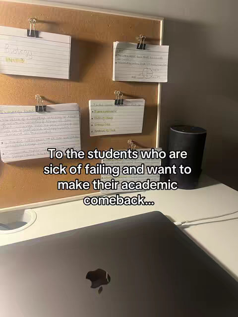The image shows a workspace with a corkboard, index cards, and a laptop. The corkboard has several index cards pinned to it with black clips. The index cards contain handwritten notes with titles like 'Biology' and 'Exchange Rate.' Below the corkboard is a laptop, and a smart speaker is on the right side. Text overlay at the bottom says: 'To the students who are sick of failing and want to make their academic comeback...'