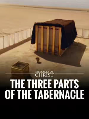 An overhead shot depicts a model of the Tabernacle, a religious structure. The scene is set against a backdrop of a desert landscape under a clear sky. The Tabernacle model has a rectangular frame with vertical timber structures. A dark, possibly black, covering drapes over the structure, creating a sense of mystery. Adjacent to the main structure is a smaller rectangular structure and a tall, vertical pillar.