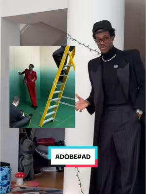 The cover image is a multi-layered composition. On the right side, a man in a black suit and cap poses, looking towards the viewer with his arms open. The background is the interior of a building with a bright white wall. A smaller image is overlaid on the left with a man in a red suit, as if he is on a movie set. A yellow ladder is present in the set. A banner that reads ADOBE#AD in a colorful box.