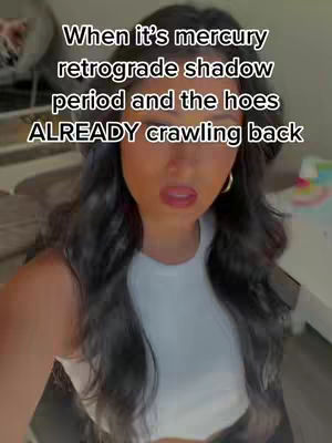 A selfie-style video featuring a woman with dark hair and a white top. The text overlay reads, 'When it's mercury retrograde shadow period and the hoes ALREADY crawling back.' The woman has a slightly surprised expression.