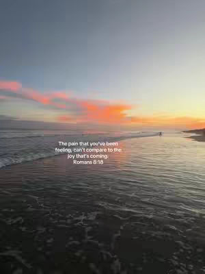 A scenic view of a beach at sunset or sunrise, with calm water reflecting the sky's colors.