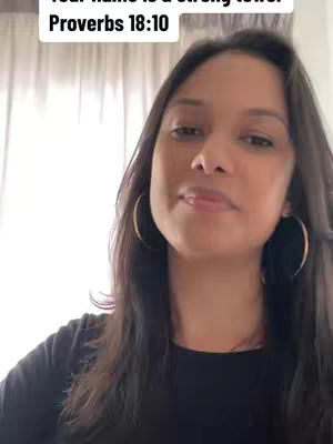 A woman with long dark hair and hoop earrings faces the camera, looking slightly to the side, against a bright background.