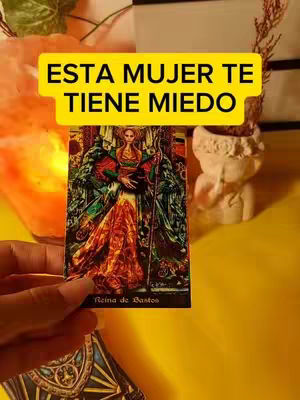 The cover image displays a tarot card from the Reina de Bastos deck, held up by a hand against a brightly lit yellow background. A yellow rectangle across the top has the text, "ESTA MUJER TE TIENE MIEDO". In the background is a carved bust on the right, and an orange light source on the left.
