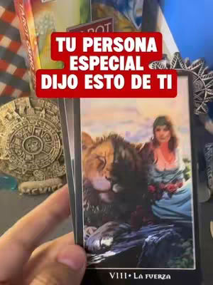 The image features a close-up of a tarot card held in a hand, with other cards and objects visible in the background. The main card shows an illustration of a woman with a lion, with hook text overlayed.