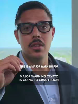 A man wearing glasses with text overlayed. The man is in front of a light blue background and a window. The text says "THIS IS A MAJOR WARNING FOR MAJOR WARNING CRYPTO IS GOING TO CRASH SOON."