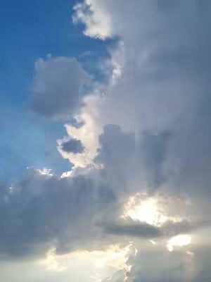 The cover image is of a sky filled with clouds. The sky is gradients of blue and grey, with rays of light shining through a break in the clouds.