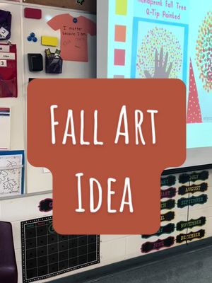 The cover image shows a teacher's classroom. Prominently displayed is a large, light-orange rectangle with the words 'FALL ART IDEA' in white, bold font. To the right is a screen displaying a handprint tree art project. Other elements include a bulletin board with calendar months, a whiteboard with magnets, a shirt with a message, and other classroom decorations.