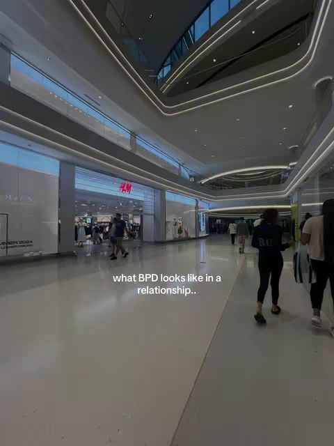 The cover image shows a wide shot inside a modern shopping mall. The ceiling has architectural designs with bright lights. A store with the 'H&M' logo is visible in the background, and several people are walking in the corridor.