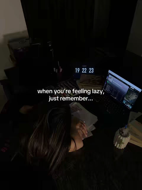 A dark, moody scene shows a person with long hair lying on a desk, suggesting they are tired. Papers and a laptop are visible, and text overlays suggest a study-related theme.