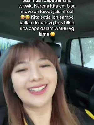 A woman in a car is smiling and looking at the camera. Overlayed text is visible over the image.