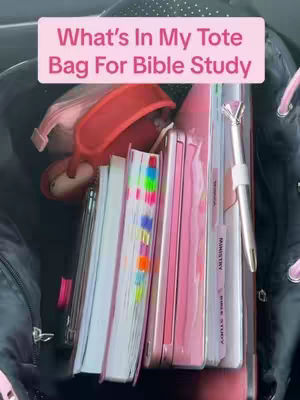 The cover image shows the contents of a tote bag, including books, notebooks, a pen, and other personal items. The bag is black, and the items are mostly pink, white, and colorful. A text overlay in a lighter pink rectangle reads, "What's In My Tote Bag For Bible Study."