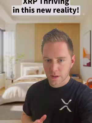 A man in a black shirt with a white XRP logo stands in front of a bedroom, the overlayed text reads "XRP Thriving in this new reality!"