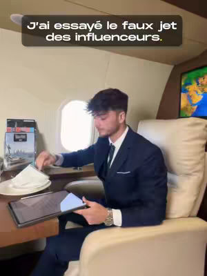 A man in a suit sits inside what appears to be a private jet, working on a tablet. Above him is a text overlay reading "J'ai essayé le faux jet des influenceurs."