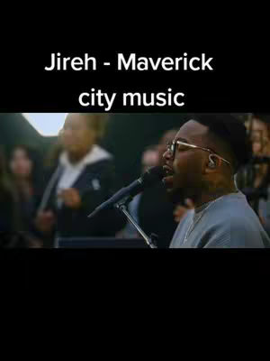 The image shows a man singing into a microphone with other people in the background, the image has text overlay at the top.