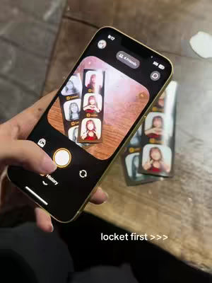 The cover shows a person holding a gold iPhone. On the phone is a photo frame-like view displaying a series of photo booth-style images against a wooden table surface.