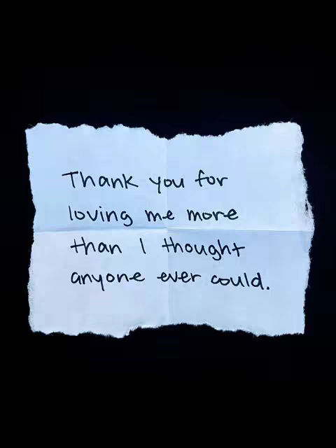 A rectangular piece of torn paper with the text 'Thank you for loving me more than I thought anyone ever could' written in black ink. The paper is off-white, with a slightly rough and uneven edge.