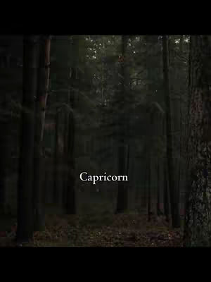 A dark, moody image of a forest with tall, thin trees. The word "Capricorn" is written in white text in the center of the image.