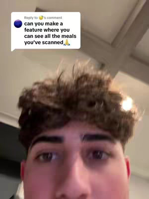 A selfie style shot featuring a young man's face filling most of the frame. He has short, textured brown hair, dark eyebrows, and is looking directly at the camera. A speech bubble containing text is visible in the upper left corner, and the background appears to be a room interior with visible ceiling lines.