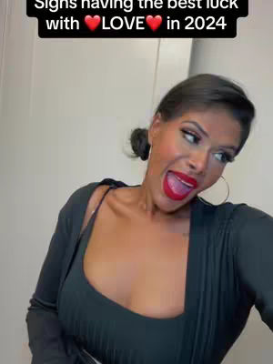 A woman with dark hair and makeup is smiling widely with red lipstick and a black top. Text on a black background says Signs having the best luck with LOVE in 2024.