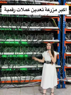 A woman in a white dress stands in front of a wall of computer hardware with green lights. The layout emphasizes technology and information.